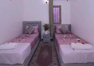 two beds sitting next to each other in a room at Hotel Riad Fantasia in Marrakech