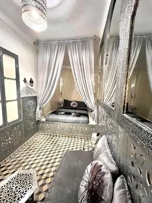 a bedroom with a bed and a large mirror at Riad 1001 couleurs in Marrakech