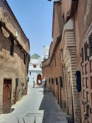 a group of people walking down an alley at Riad 1001 couleurs in Marrakech