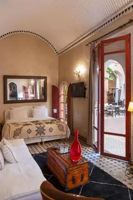 a bedroom with a bed and a red vase on a table at Indian Palace in Marrakech