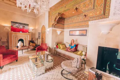 a woman sitting on a couch in a living room at Indian Palace in Marrakech