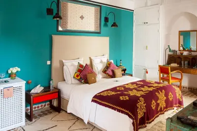 a bedroom with a large bed with blue walls at Indian Palace in Marrakech