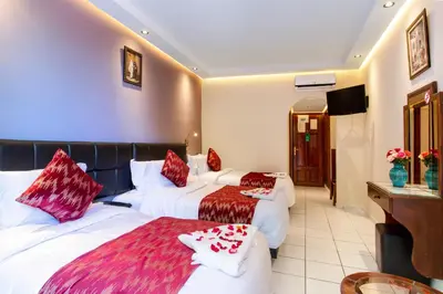 a hotel room with two beds and a television at Hotel Akabar in Marrakech