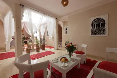a living room with a table and chairs and a dining room at Riad Makech in Marrakech