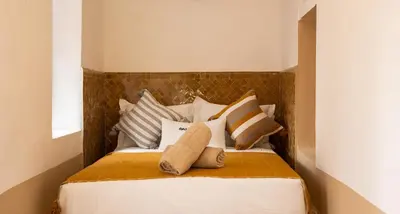 a bedroom with a bed with pillows on it at Riad El Jadide in Marrakech