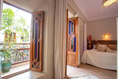 a bedroom with a bed and a large window at Riad Darino Marrakech Heritage in Marrakech