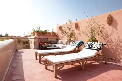 a patio with two benches and a table on a balcony at Riad Zineb in Marrakech