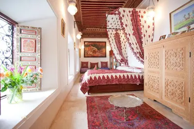 a bedroom with a bed and a window and a rug at Riad Zineb in Marrakech