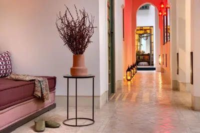 a hallway with a couch and a vase on a table at Riad Antara in Marrakech