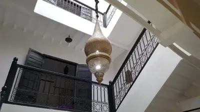 a large light fixture hanging from a stairway at Riad Naim in Marrakech