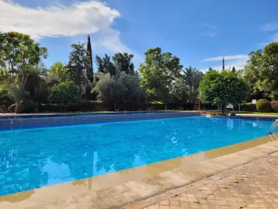 a swimming pool in a villa with trees at Palmeraie village 2 , les jardins de la palmeraie 2 in Marrakech