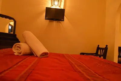 a bedroom with a bed with a towel on it at Hotel Amalay in Marrakech
