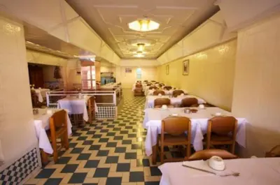 a row of tables in a restaurant with white table cloth at Hotel Amalay in Marrakech