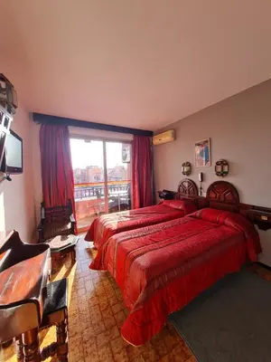 a hotel room with two beds and a window at Hotel Tachfine in Marrakech