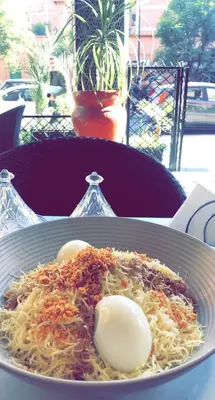 a plate of spaghetti with eggs on a table at Hotel Tachfine in Marrakech