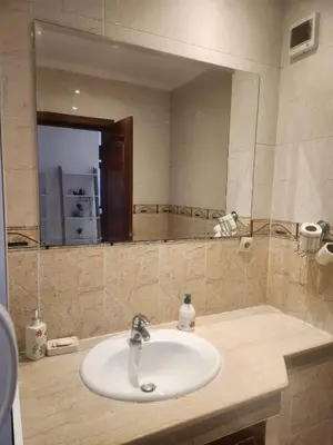 a bathroom with a sink and a large mirror at Appartement Centre Gueliz Hanane in Marrakech