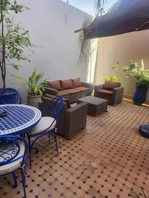 a patio with a table and chairs and a couch at Appartement Centre Gueliz Hanane in Marrakech