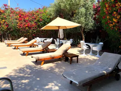 a row of lounge chairs and an umbrella at Palais Souad in Marrakech