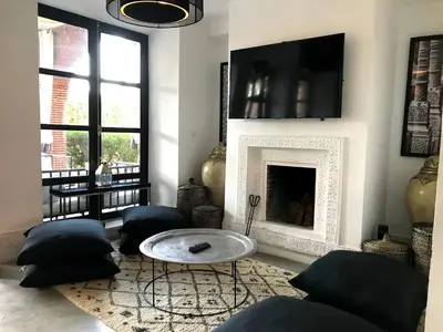 a living room with a table and a fireplace at Palais Souad in Marrakech