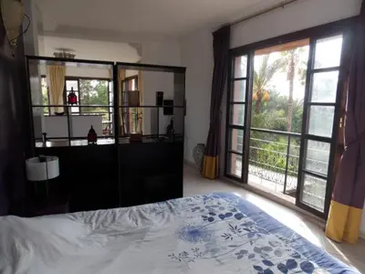 a bedroom with a bed and a large window at Appart avec vue Jardin/Majorelle in Marrakech