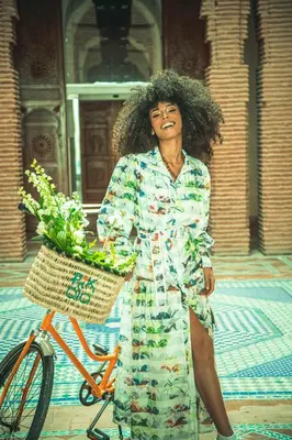 a woman standing next to a bike with a basket at Jaal Riad Resort Adults Only in Marrakech
