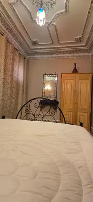 a bedroom with a bed and a table and a chair at Riad Raffaa in Marrakech