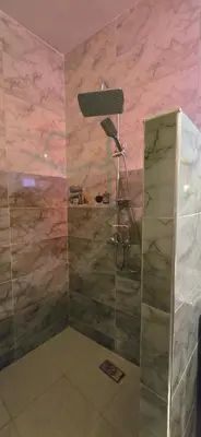 a shower in a room with pink marble walls at Riad Raffaa in Marrakech