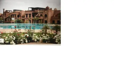 a picture of a resort and a picture of a flower garden at Magnifique Appt Atlas Golf Resort Marrakech in Marrakech