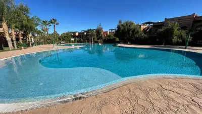 a large swimming pool with blue water at Magnifique Appt Atlas Golf Resort Marrakech in Marrakech