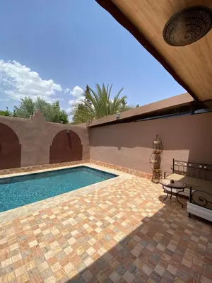 a swimming pool with a table and a bench at Villa des Roses Privée in Marrakech