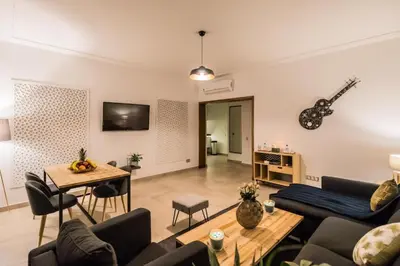 a living room with a couch and a guitar on the wall at M Appart in Marrakech