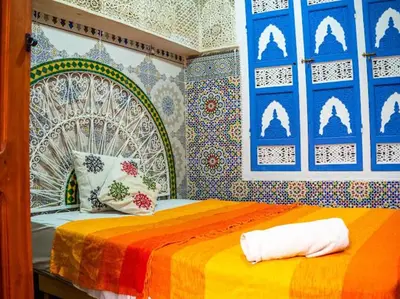 a bedroom with a bed with a colorful bedspread at Dar Sarsar Artistic Music in Marrakech