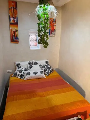 a bedroom with a bed with colorful blankets and pillows at Riad Sarsar Dar dmana in Marrakech