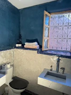 a bathroom with a toilet and a window at Riad Sarsar Dar dmana in Marrakech