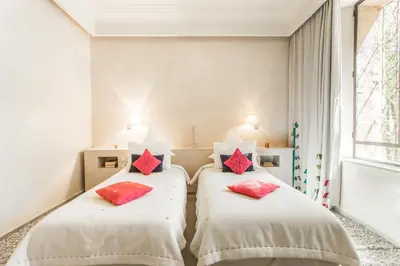 two beds in a room with red pillows on them at Villa YENMOZ en exclusivité avec piscine privée dans la Palmeraie in Douar Caïd Layadi