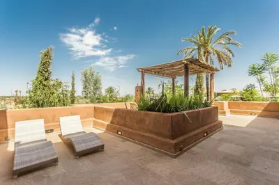 two chairs and a gazebo on a patio at Villa YENMOZ en exclusivité avec piscine privée dans la Palmeraie in Douar Caïd Layadi