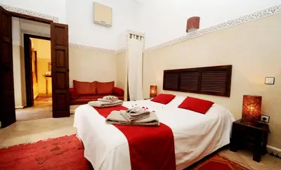 a bedroom with a large bed with red pillows on it at Riad Elias & Spa in Marrakech
