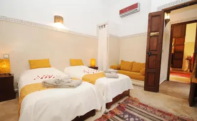 a room with two beds and a couch at Riad Elias & Spa in Marrakech
