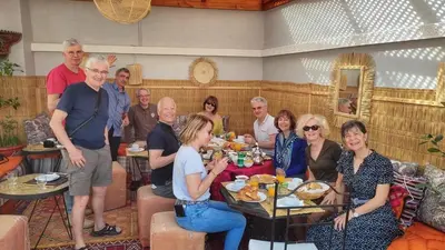 a group of people sitting around a table in a living room at Riad Zahri in Marrakech