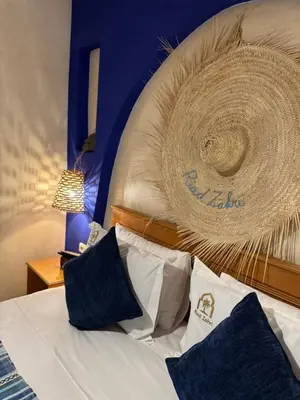 a bedroom with a bed with a rattan headboard at Riad Zahri in Marrakech