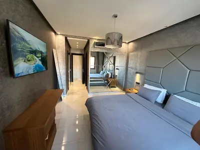 a bedroom with a large white bed and a mirror at Sweet Jacob's Appartment Gueliz City Center in Marrakech