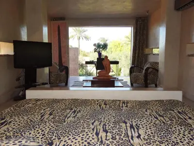a bedroom with a bed and a television and a desk at Dar Sabra in Marrakech