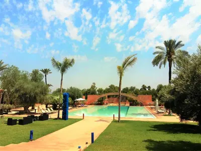 a pool at a resort with palm trees at Dar Sabra in Marrakech