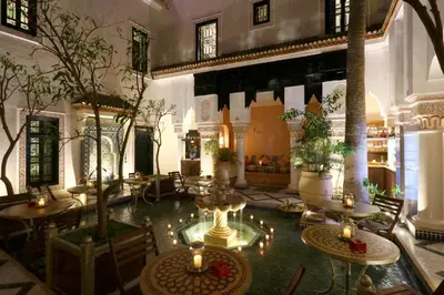 a large room with tables and chairs and trees at Riad Omara al Kasbah in Marrakech