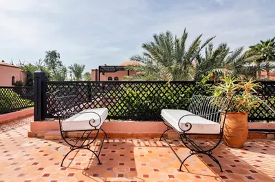 two white chairs on a patio with a fence at Maison Ayda in Marrakech