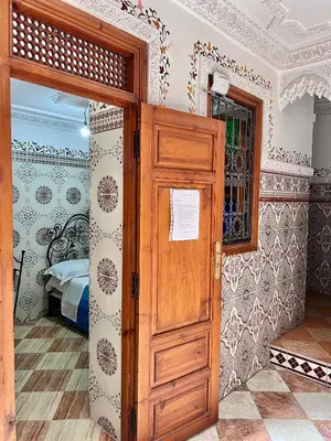 a room with a wooden door and a bedroom at Hotel Medina in Marrakech
