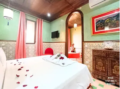a bedroom with a white bed and a fireplace at Riad la villa bleue & SPA in Marrakech