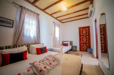 a living room with two beds and a window at Riad Arabic House & Spa in Marrakech
