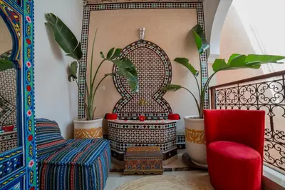 a room with a chair and a table and some plants at Riad Arabic House & Spa in Marrakech