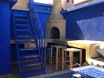 a blue room with a staircase and two stools at Riad Côté palmeraie in Marrakech